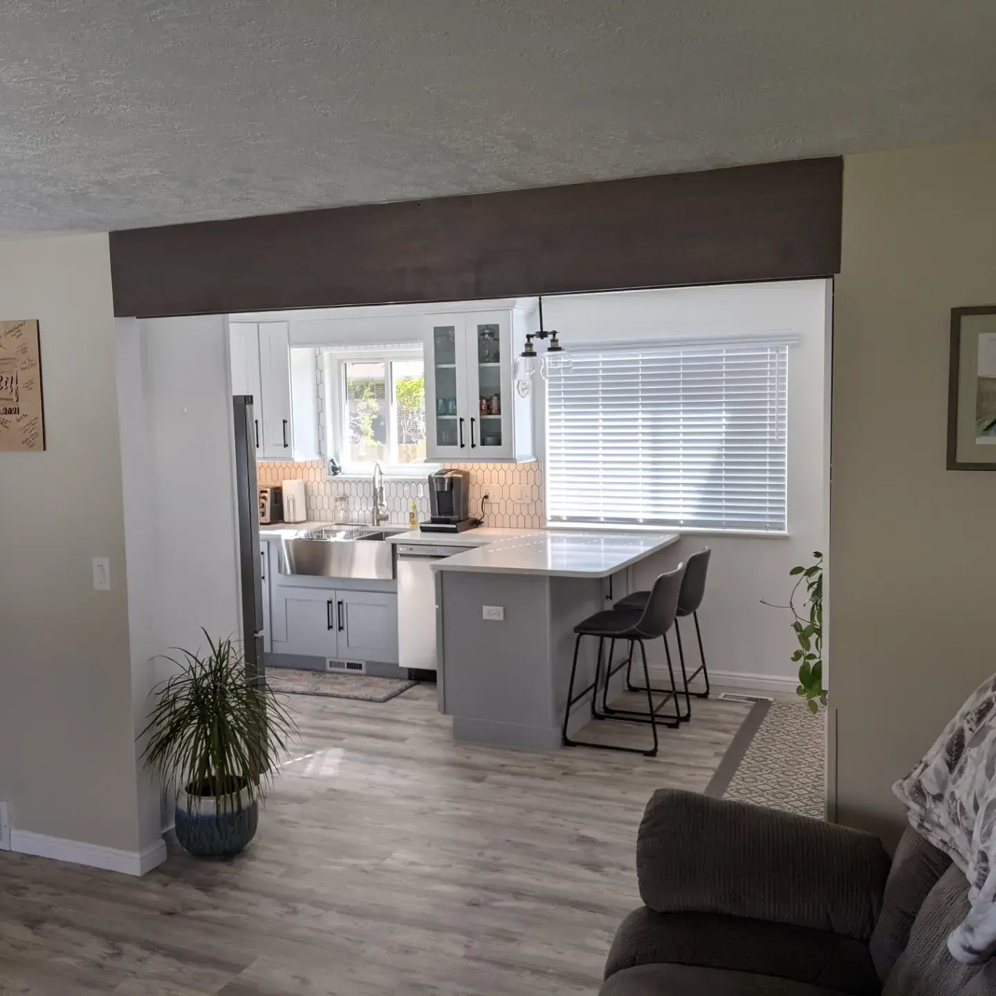 Open-concept kitchen and living room remodel with a gray kitchen island and bar seating