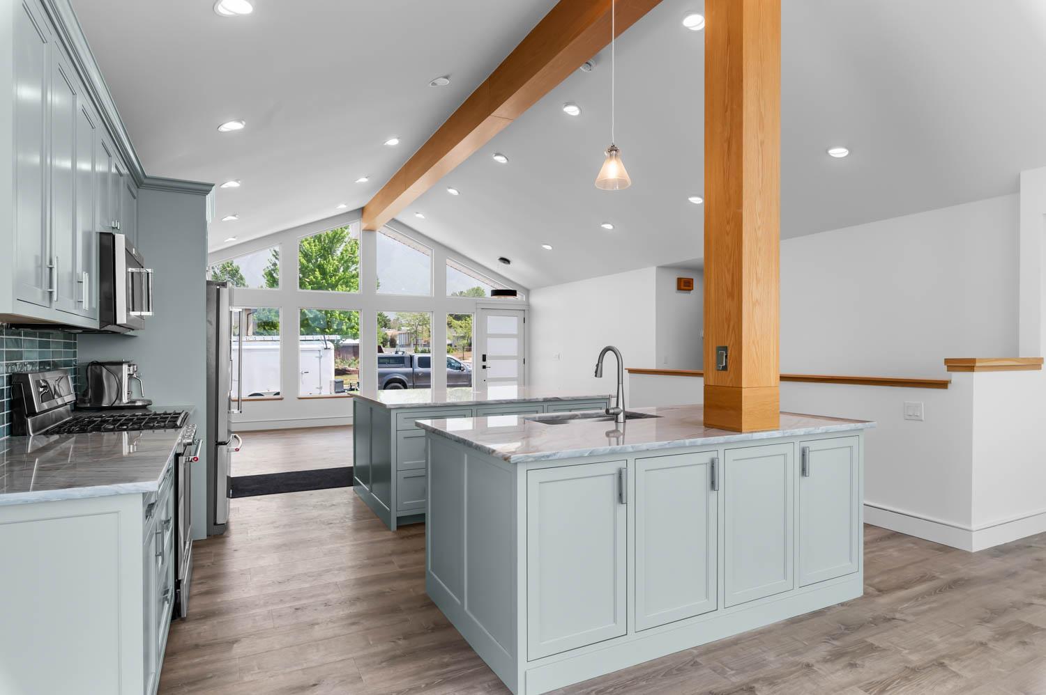 Open-concept kitchen and entry remodel with vaulted ceiling and an exposed wood support beam