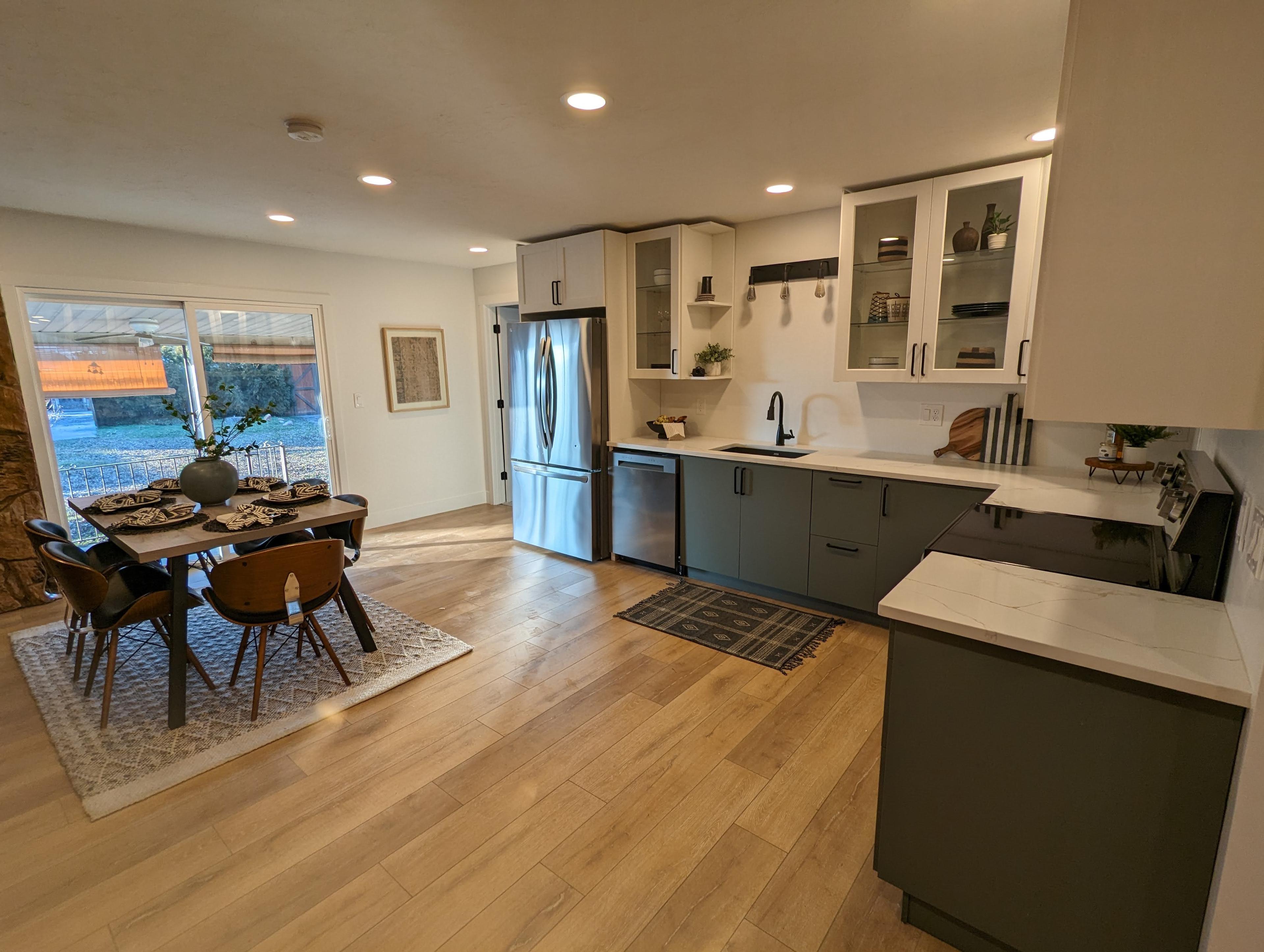 Open-concept kitchen and dining remodel with two-tone cabinetry and a farmhouse-style rug
