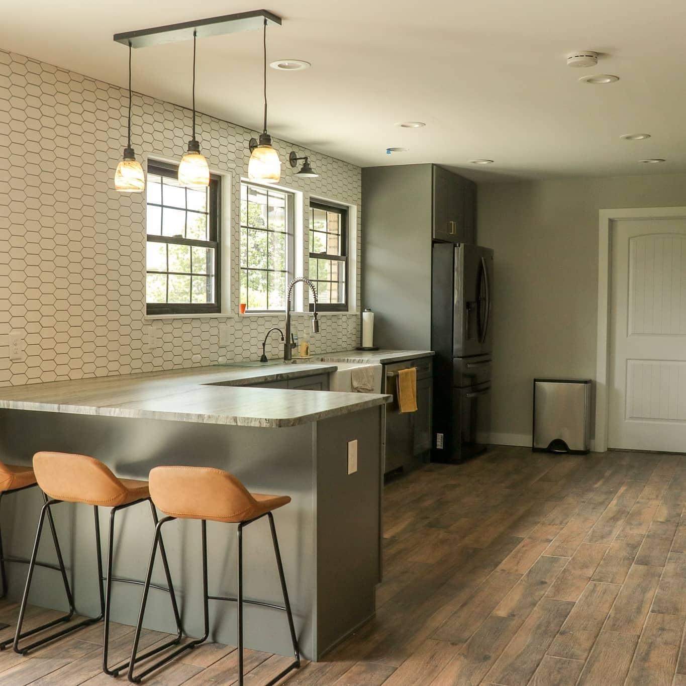 Kitchen remodel with stone countertops, a farmhouse sink, and a row of windows above
