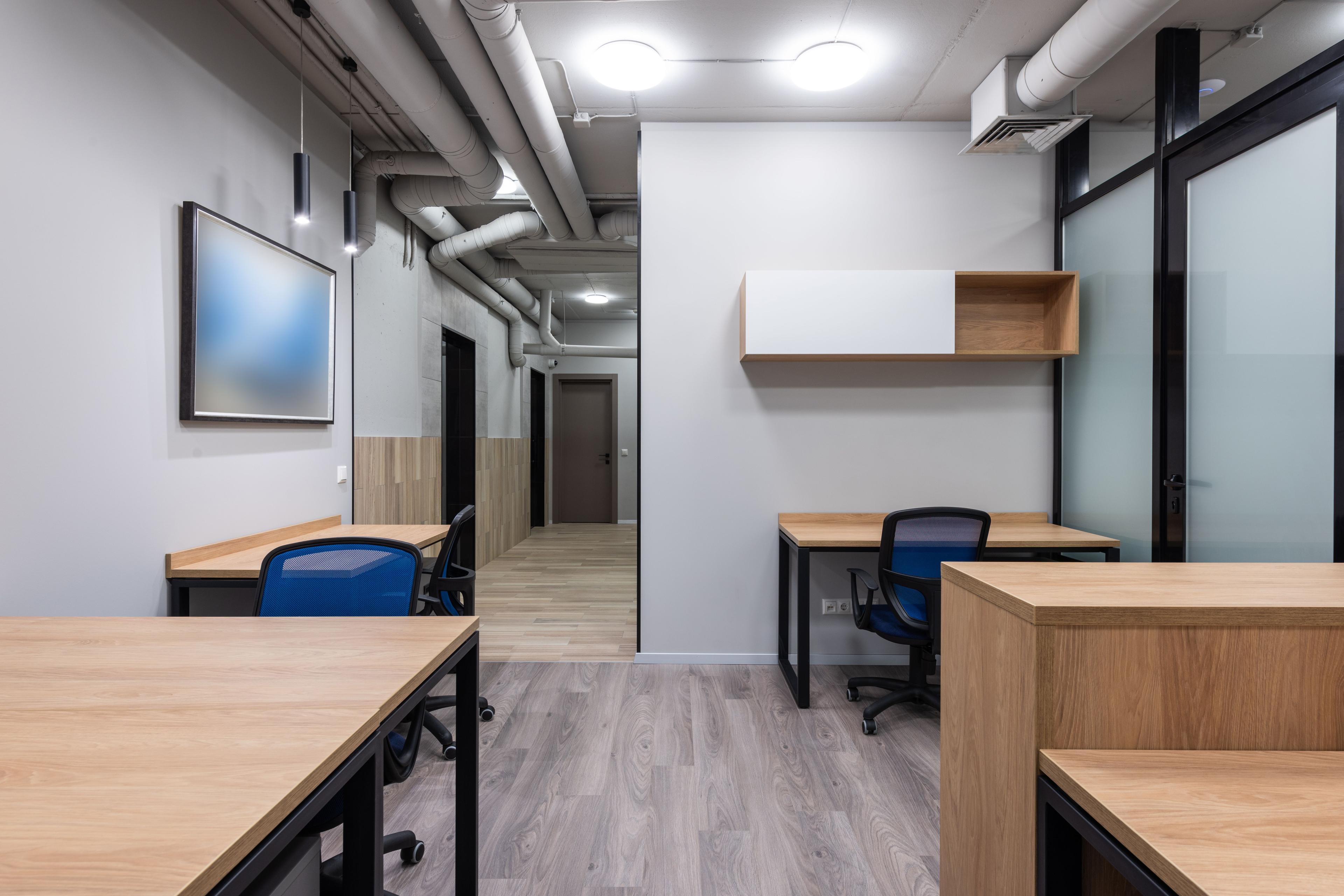 Light commercial tenant improvement build-out with open office desks and a glass-walled meeting room